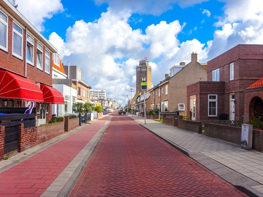 Dutch residential street with red brick houses under blue sky